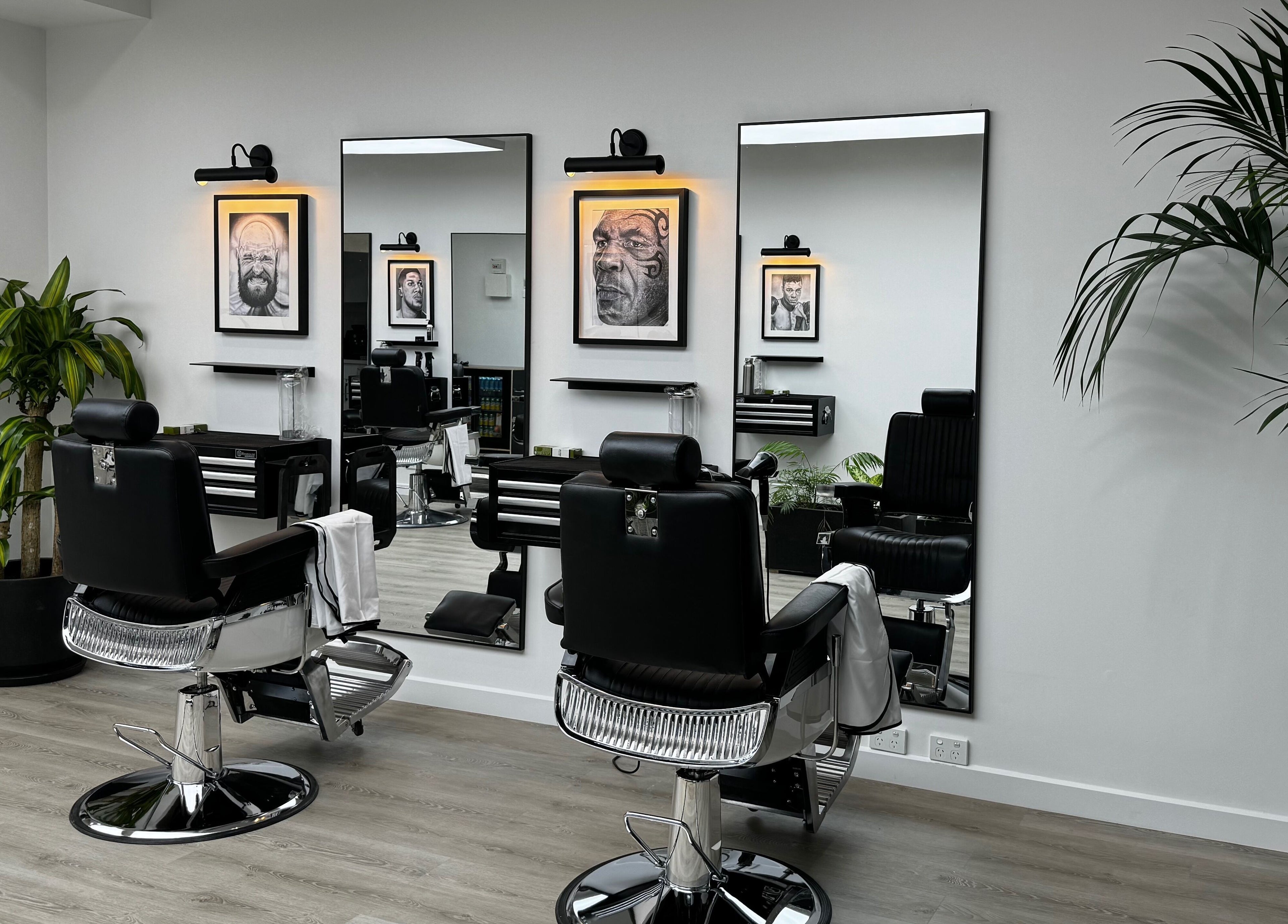 Modern interior of The Art Barbers Malvern in Melbourne, Victoria, AU with sleek chairs and art on walls.