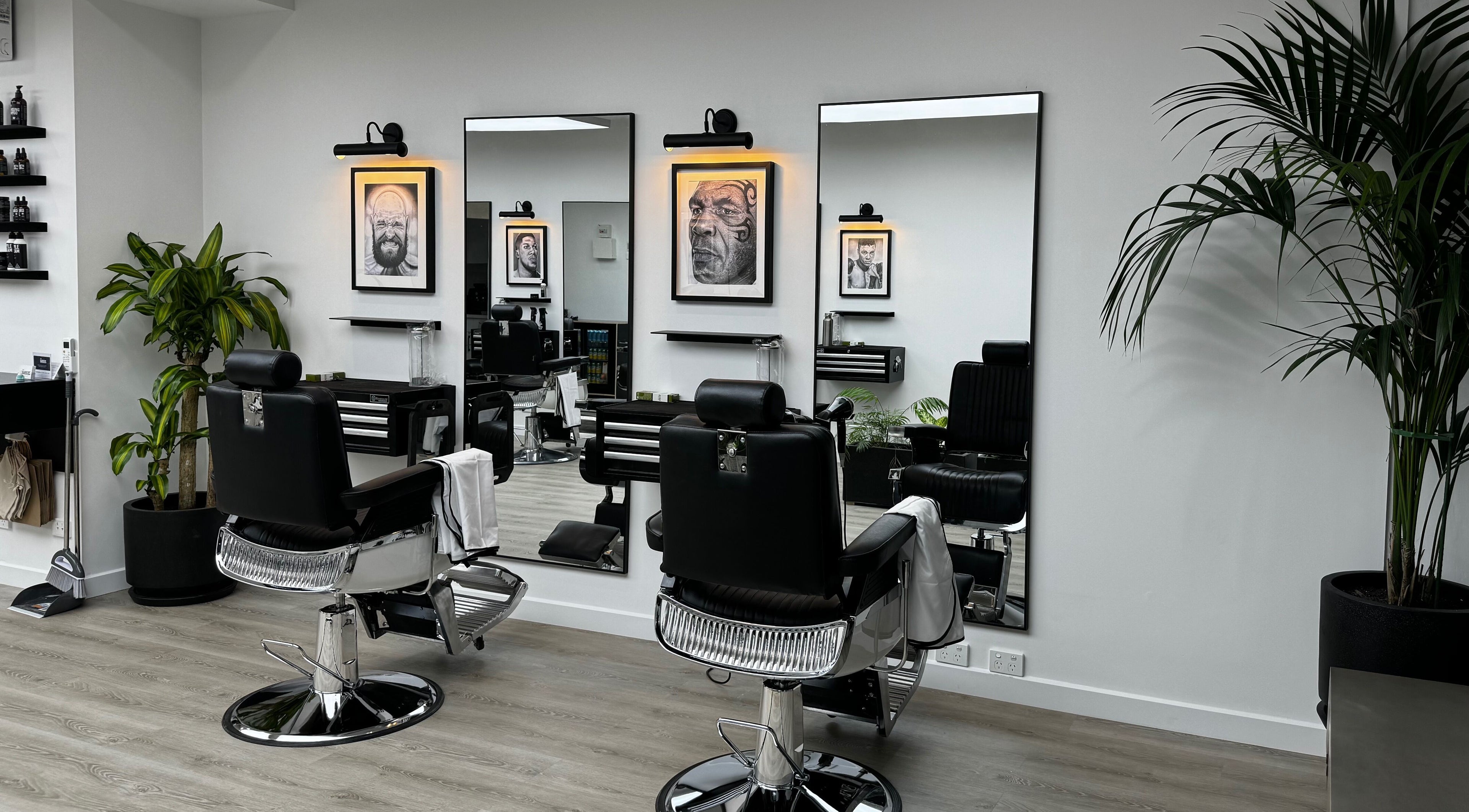 Modern interior of The Art Barbers Malvern in Melbourne, Victoria, AU with sleek chairs and art on walls.