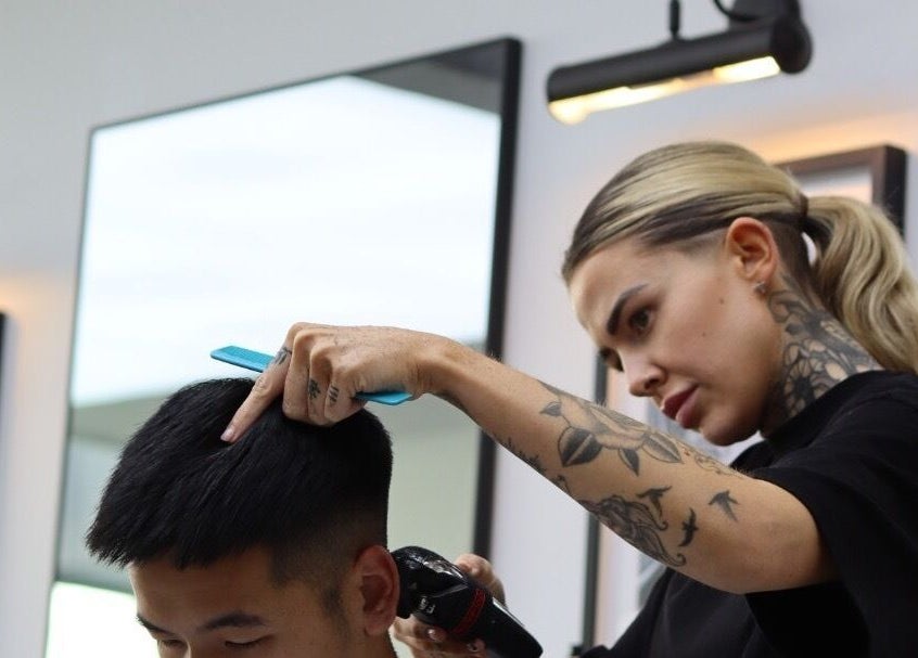 A stylist cuts hair at The Art Barbers Malvern in Melbourne, Victoria, AU, showcasing expert grooming skills.