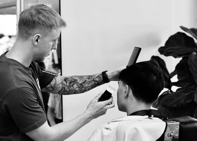 Tattooed stylist working at The Art Barbers Malvern, Melbourne, Victoria, AU offering expert haircut services.