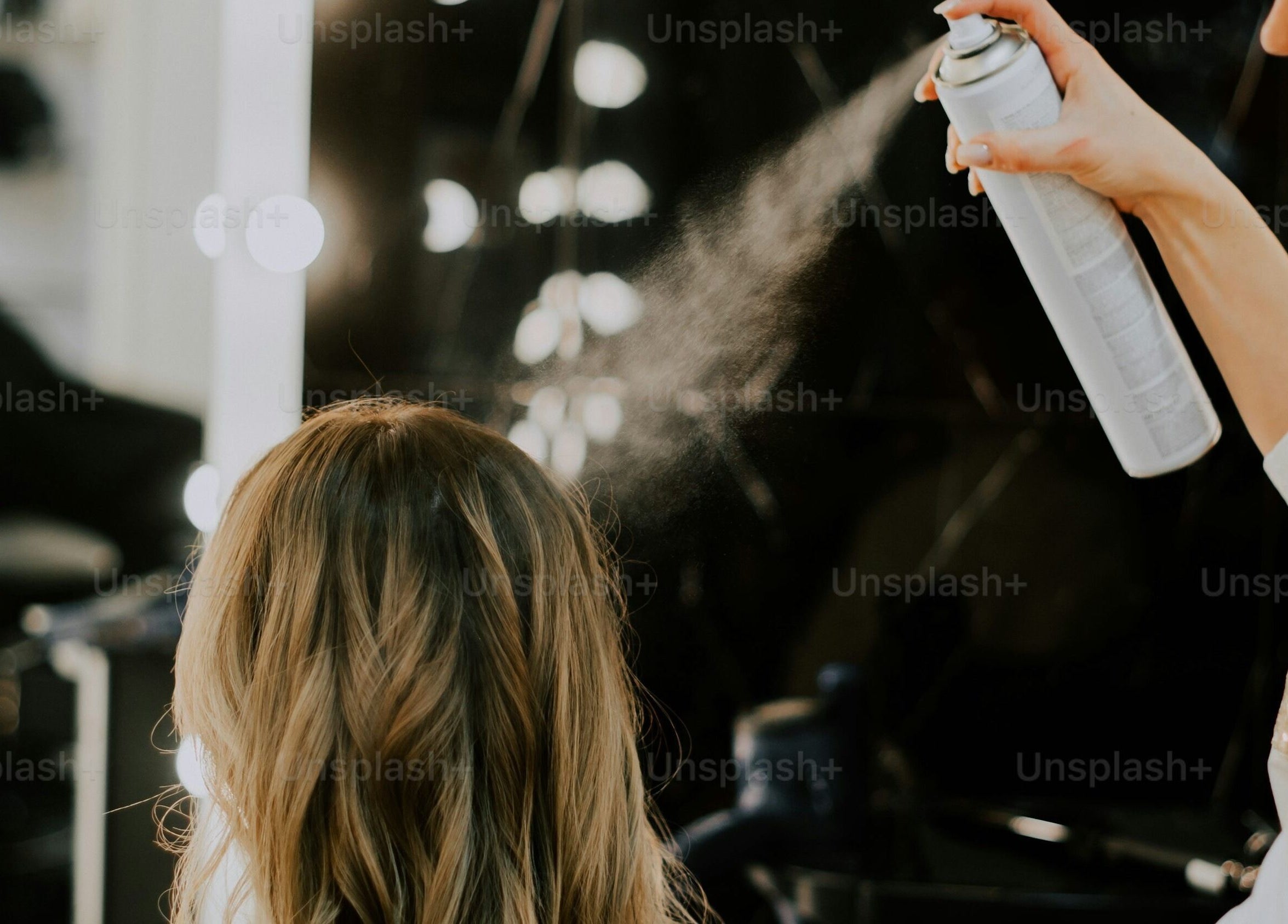 Stylist sprays hair at Bare Skin Aesthetics, Banff, Scotland, GB for a polished look.