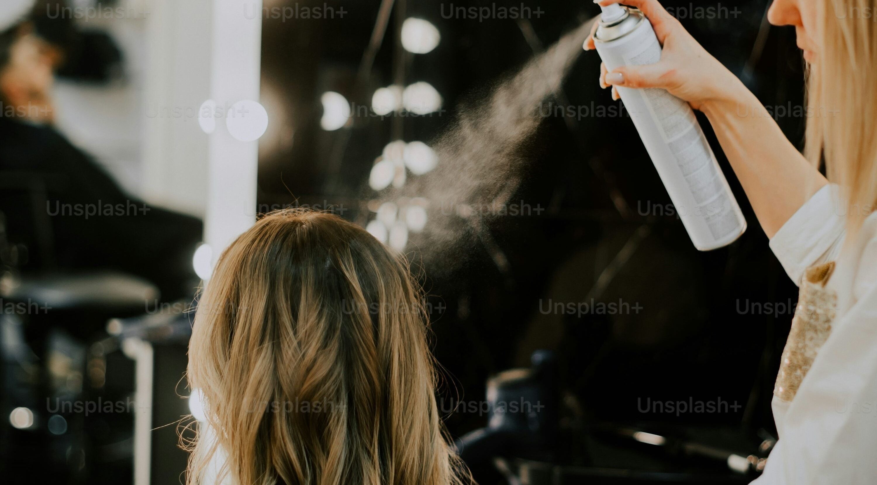 Stylist sprays hair at Bare Skin Aesthetics, Banff, Scotland, GB for a polished look.