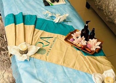 Luxurious massage table setup at Ora Spa Home Service, Riyadh, Riyadh Province, SA, with flowers and oils.