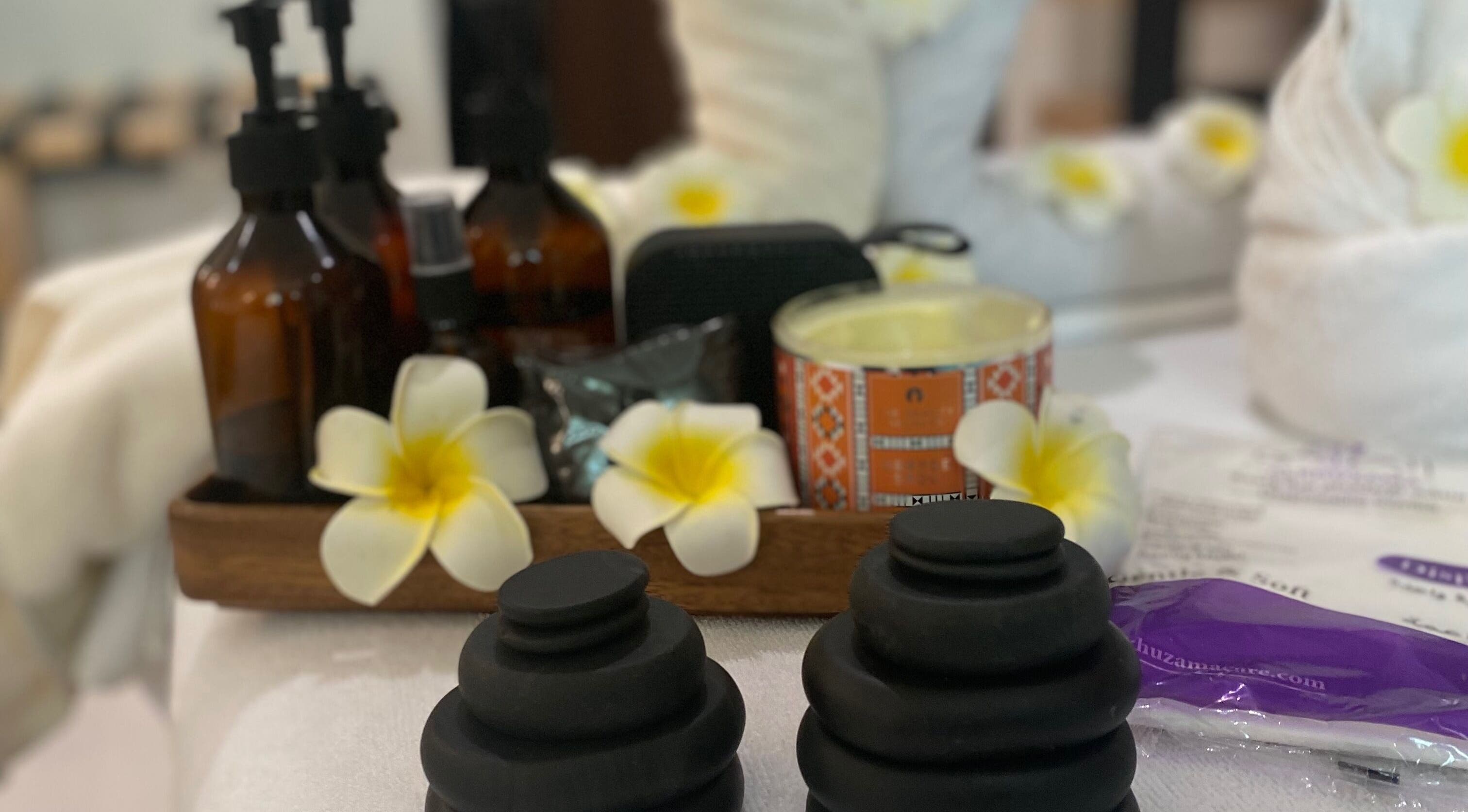 Luxurious spa setup at Ora Spa Home Service (Ladies Only) in Riyadh, featuring oils and fragrant flowers.