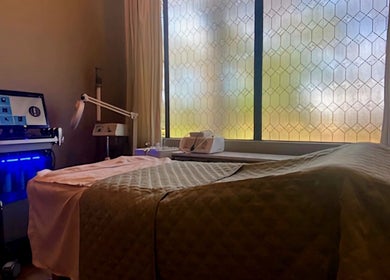 Serene facial room at The Facial and Wellness Society in The Woodlands, Texas, US with treatment bed and equipment.