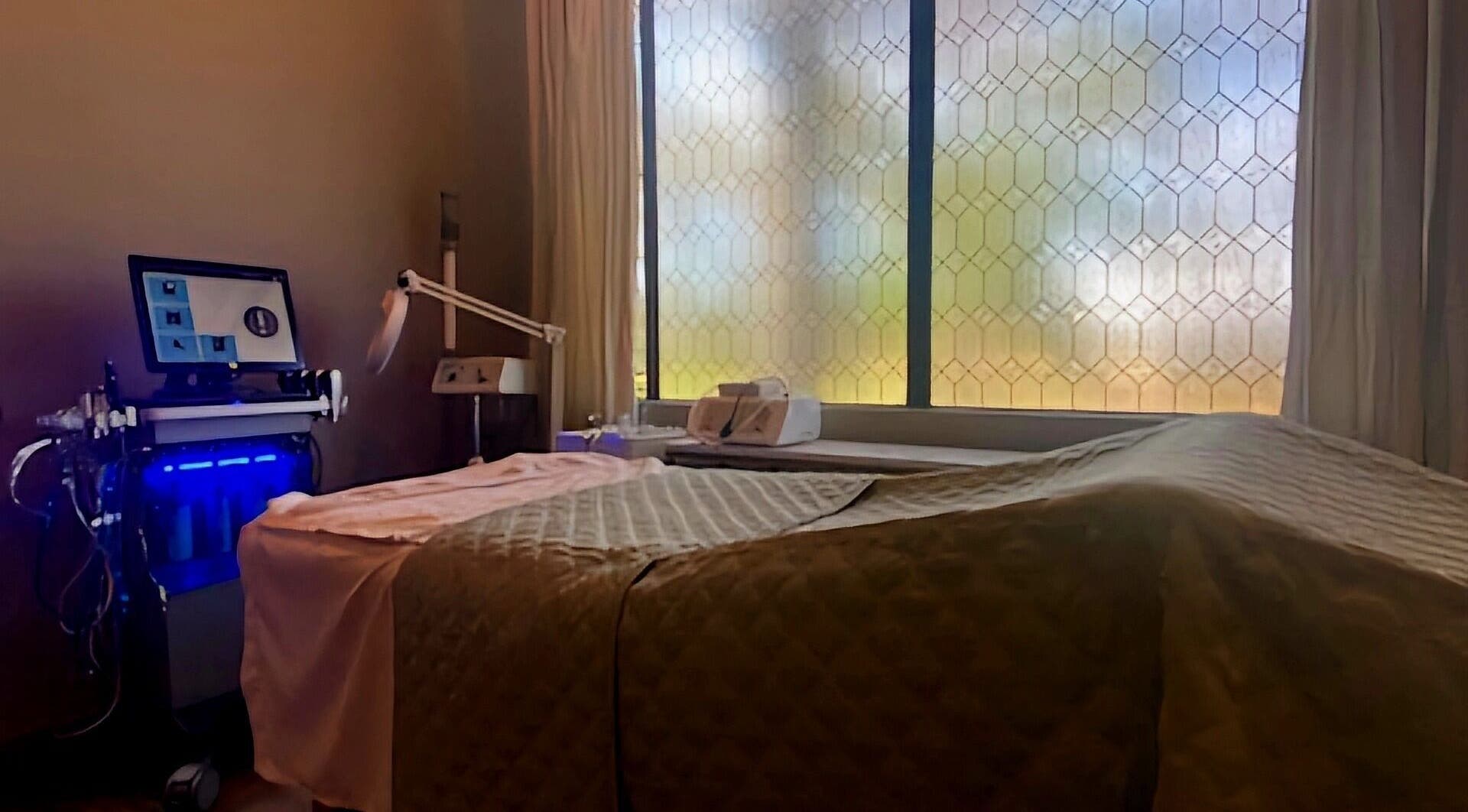 Serene facial room at The Facial and Wellness Society in The Woodlands, Texas, US with treatment bed and equipment.