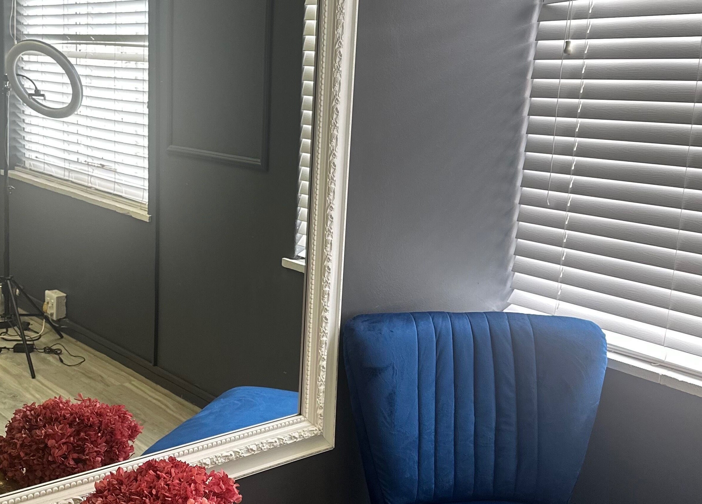 Elegant beauty corner at Bella Rose, Cape Town, Western Cape, ZA featuring a plush blue chair and ornate mirror.