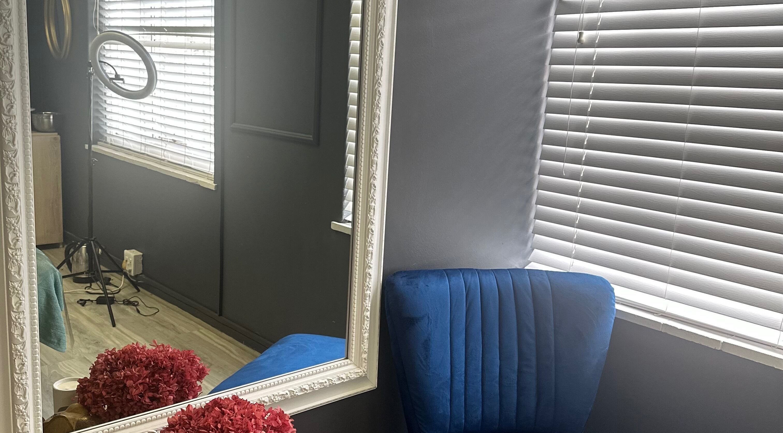 Elegant beauty corner at Bella Rose, Cape Town, Western Cape, ZA featuring a plush blue chair and ornate mirror.