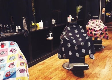 Colorful barber chairs in Oioi Barber Company South Street, Perth, GB, showcasing a lively atmosphere.
