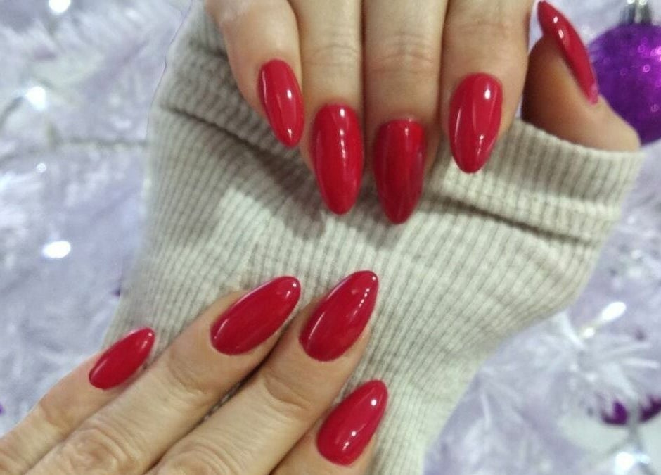 Κόκκινα γιορτινά νύχια στο Nails 4 You, Παλλήνη, GR, με φόντο χριστουγεννιάτικο δέντρο.