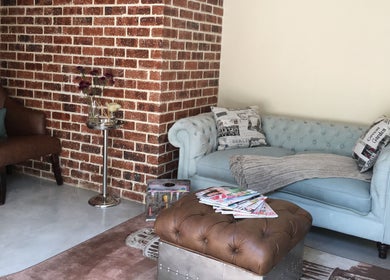 Chic lounge area at Urban Bliss Spa, Johannesburg, Gauteng, ZA featuring a plush blue sofa and classic brown chair.