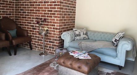 Chic lounge area at Urban Bliss Spa, Johannesburg, Gauteng, ZA featuring a plush blue sofa and classic brown chair.