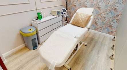 Cozy treatment room at Skin Secrets Aesthetics in Derby, England, GB, featuring a bed with a floral pillow.