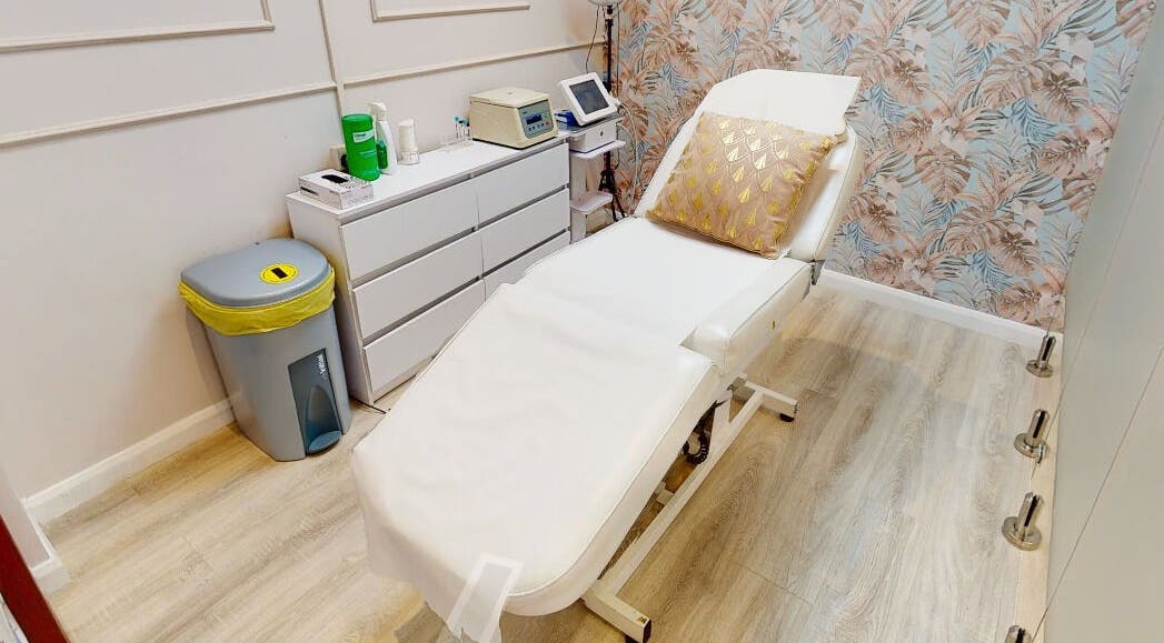 Cozy treatment room at Skin Secrets Aesthetics in Derby, England, GB, featuring a bed with a floral pillow.