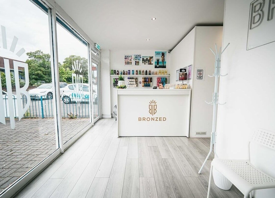Reception area of Bronzed of Broadstone in Poole, England, GB featuring sleek modern decor and product displays.