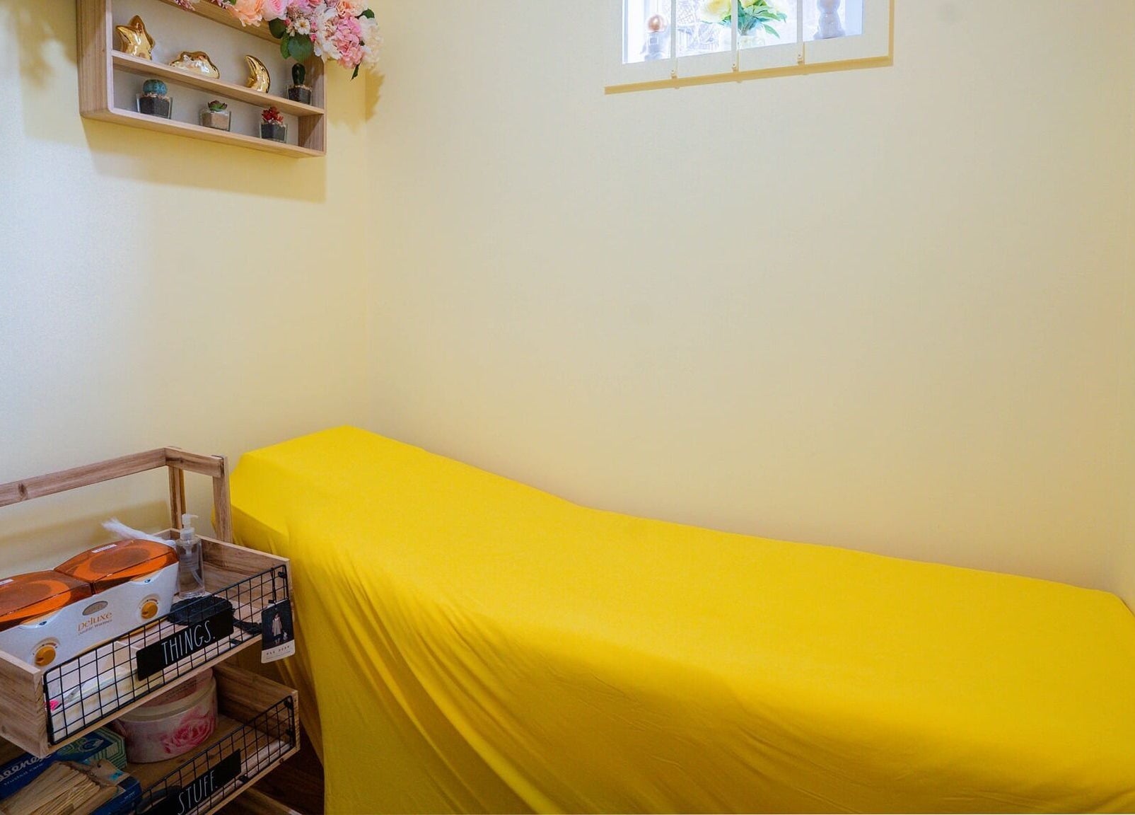 Tranquil room at Naild It Southie in South Boston, Massachusetts, US with yellow accents and serene decor.