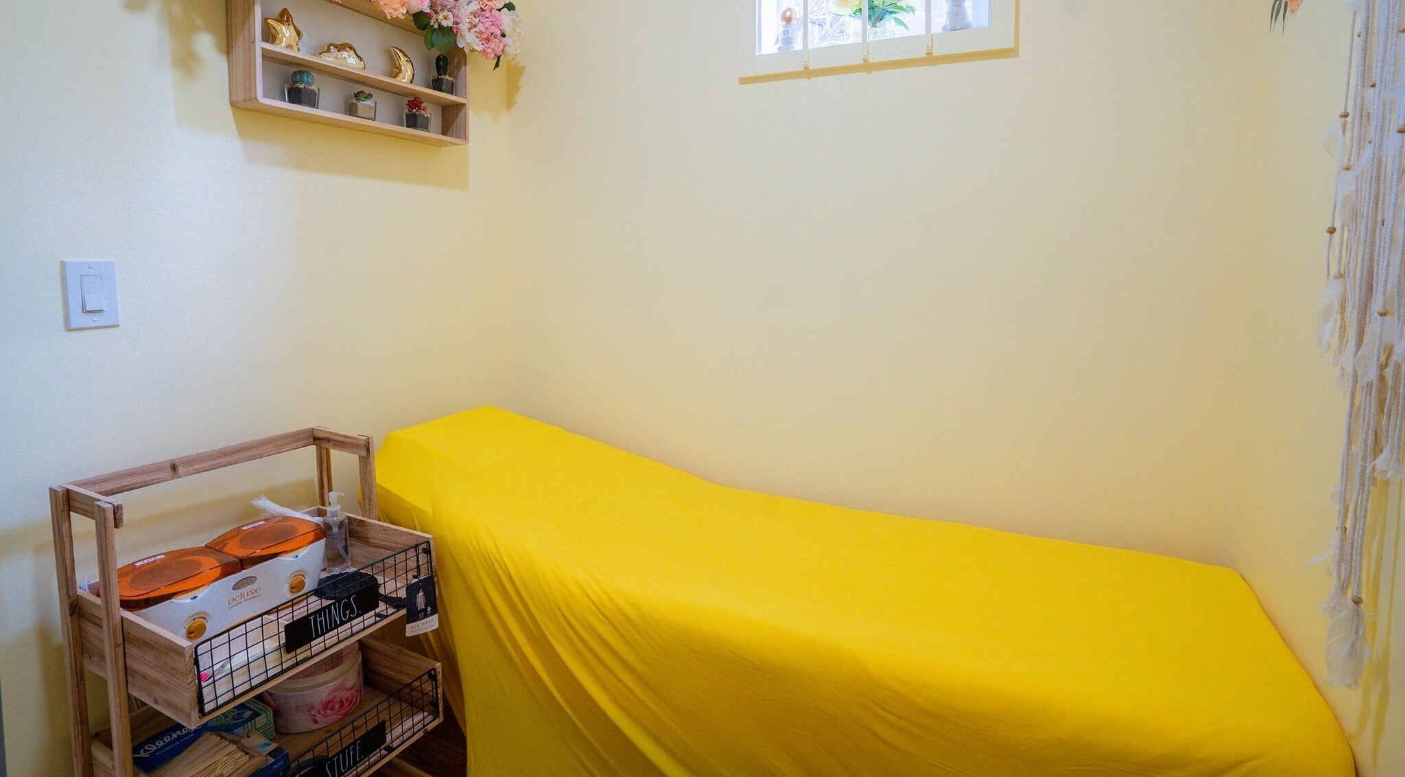 Tranquil room at Naild It Southie in South Boston, Massachusetts, US with yellow accents and serene decor.