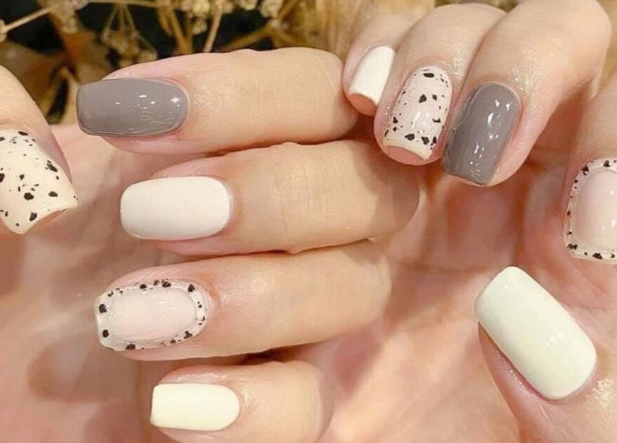 Elegant cream and gray speckled manicure at Naild It Southie, South Boston, Massachusetts, US.