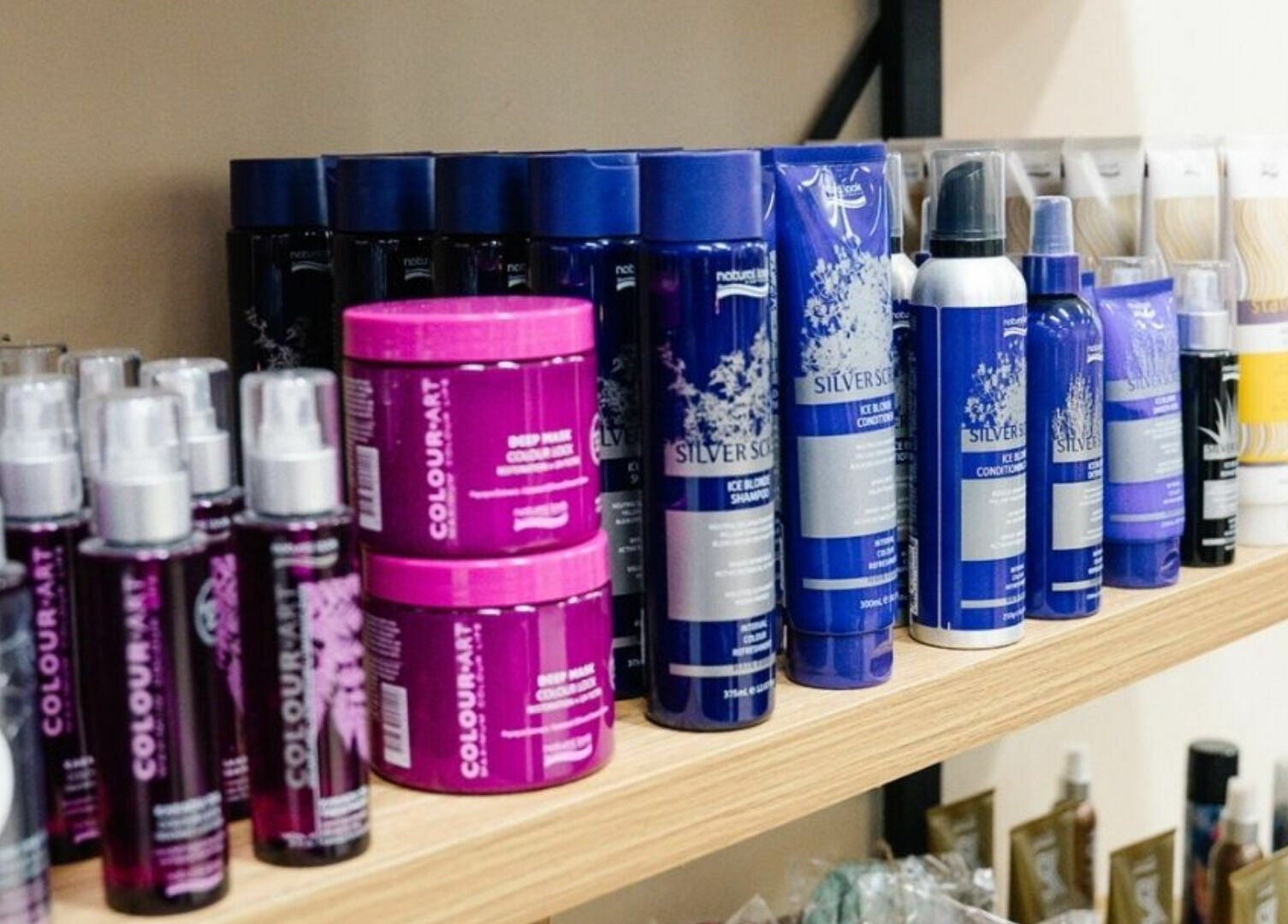 Hair care products at Meraki Curlz, Mount Sheridan, Queensland, AU, displayed on wooden shelves.