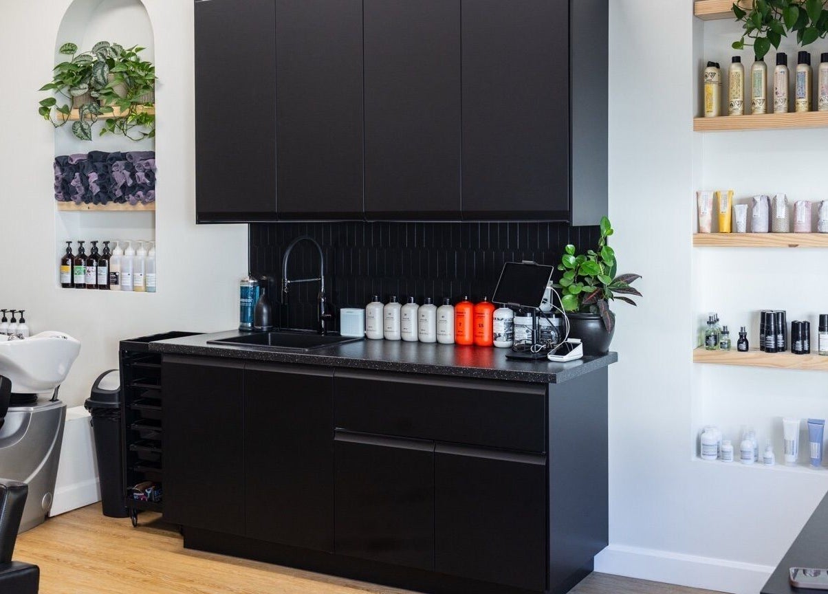 HBL Studio - Lauren Gibson's modern salon interior in Millbrook, Ontario, CA with sleek black cabinetry and product display.