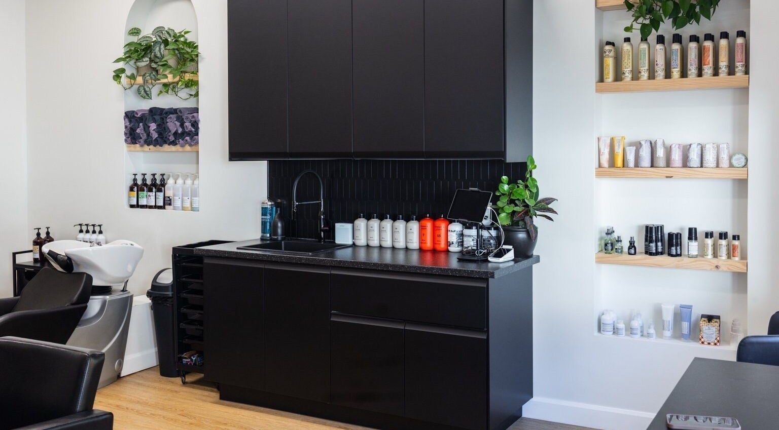 HBL Studio - Lauren Gibson's modern salon interior in Millbrook, Ontario, CA with sleek black cabinetry and product display.