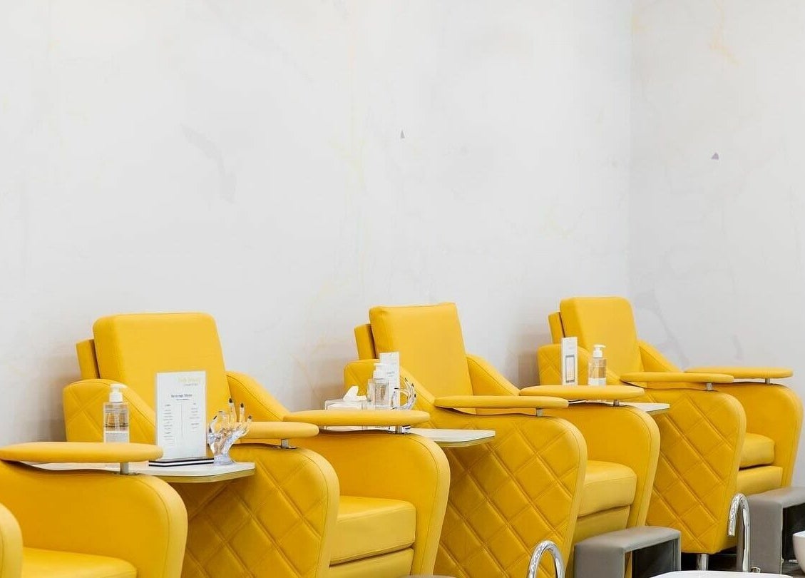 Luxurious yellow chairs at Feels Beauty Lounge and Spa, Abu Dhabi, AE ready for pedicure treatments.