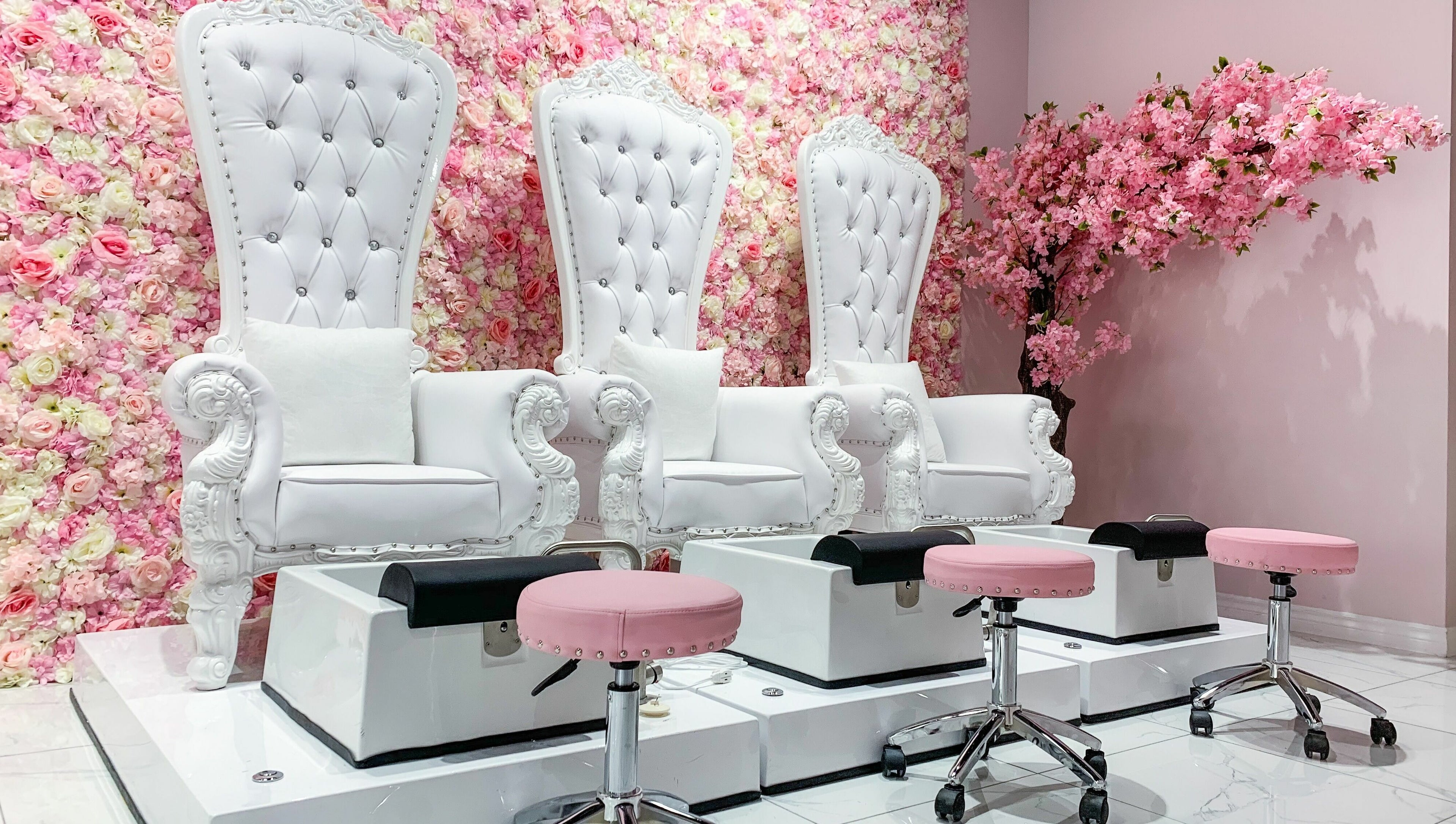 Luxurious pedicure chairs against floral wall in Goddess Salon, Toronto, Ontario, CA, enhancing serene ambiance.