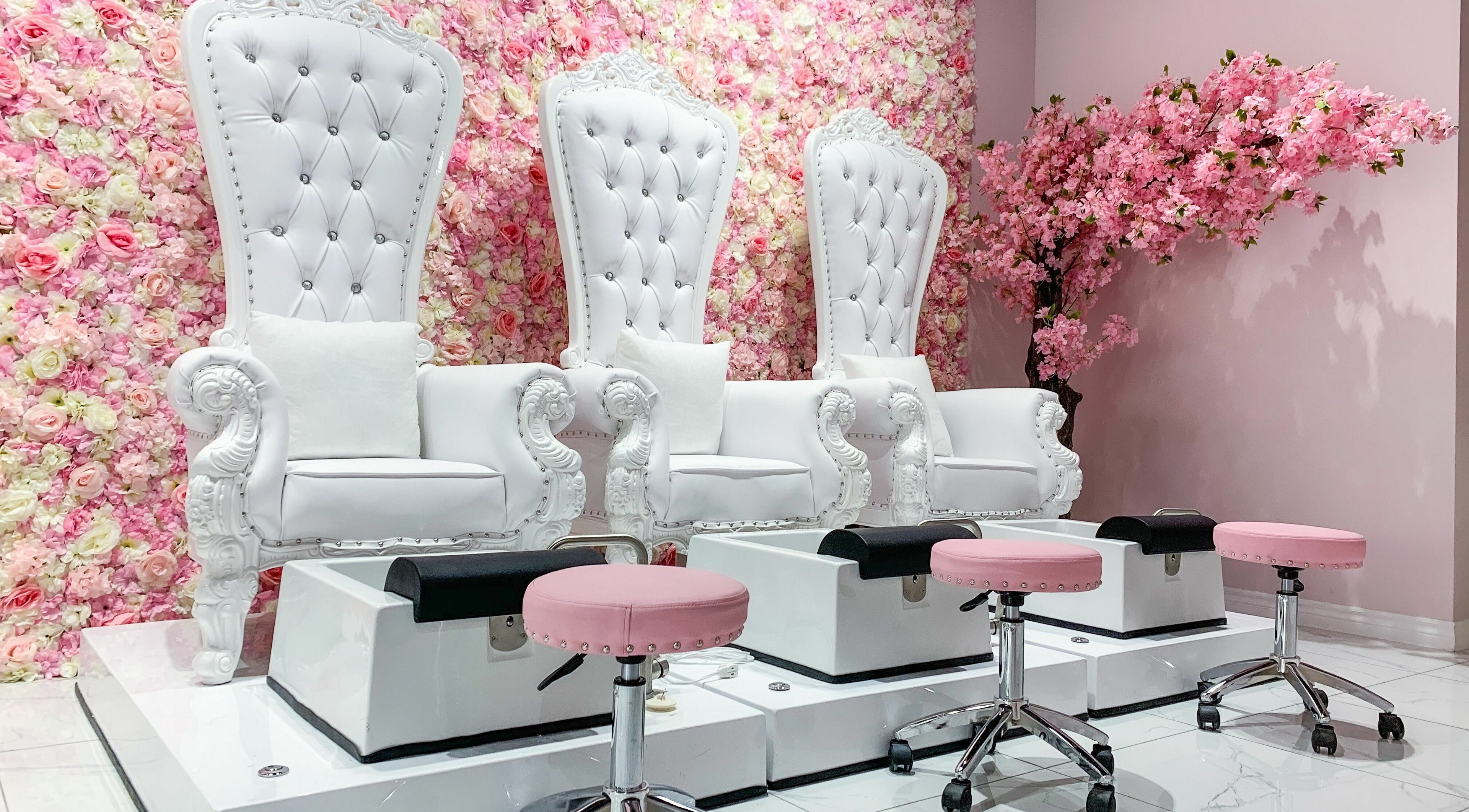 Luxurious pedicure chairs against floral wall in Goddess Salon, Toronto, Ontario, CA, enhancing serene ambiance.
