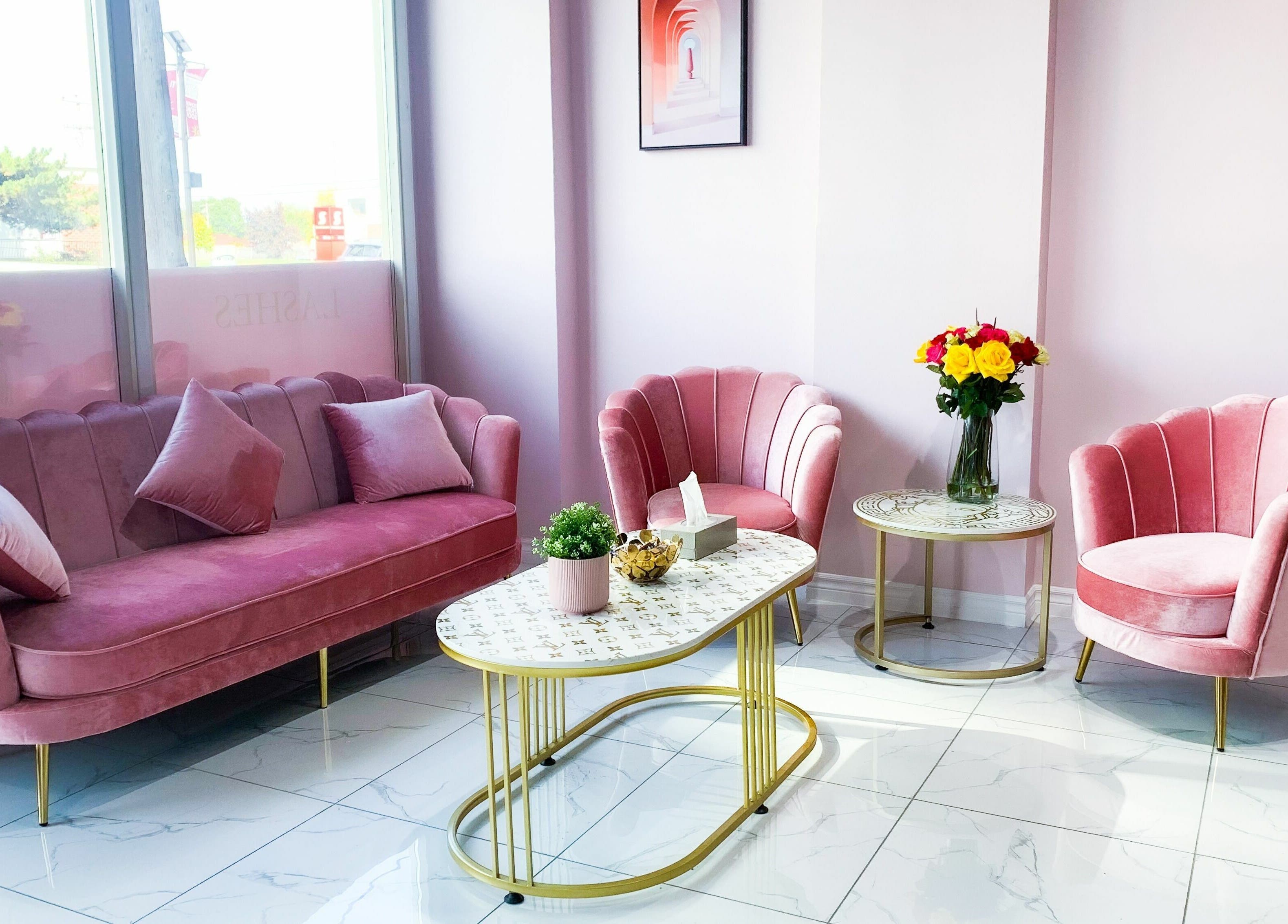 Cozy pink seating area in Goddess Salon, Toronto, Ontario, CA, with elegant chairs and table.
