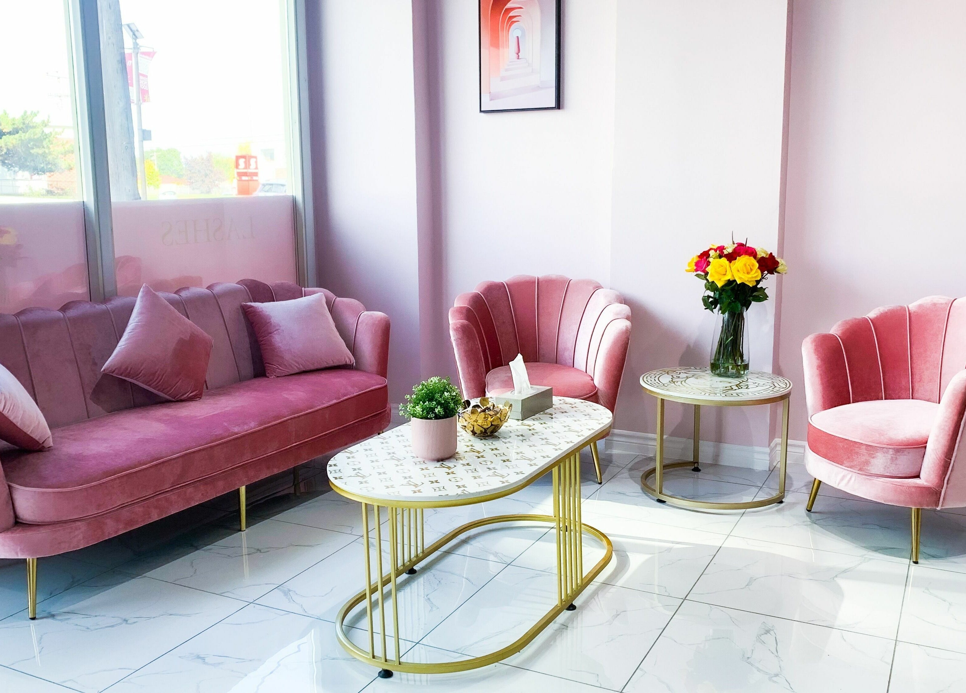 Cozy pink seating area in Goddess Salon, Toronto, Ontario, CA, with elegant chairs and table.