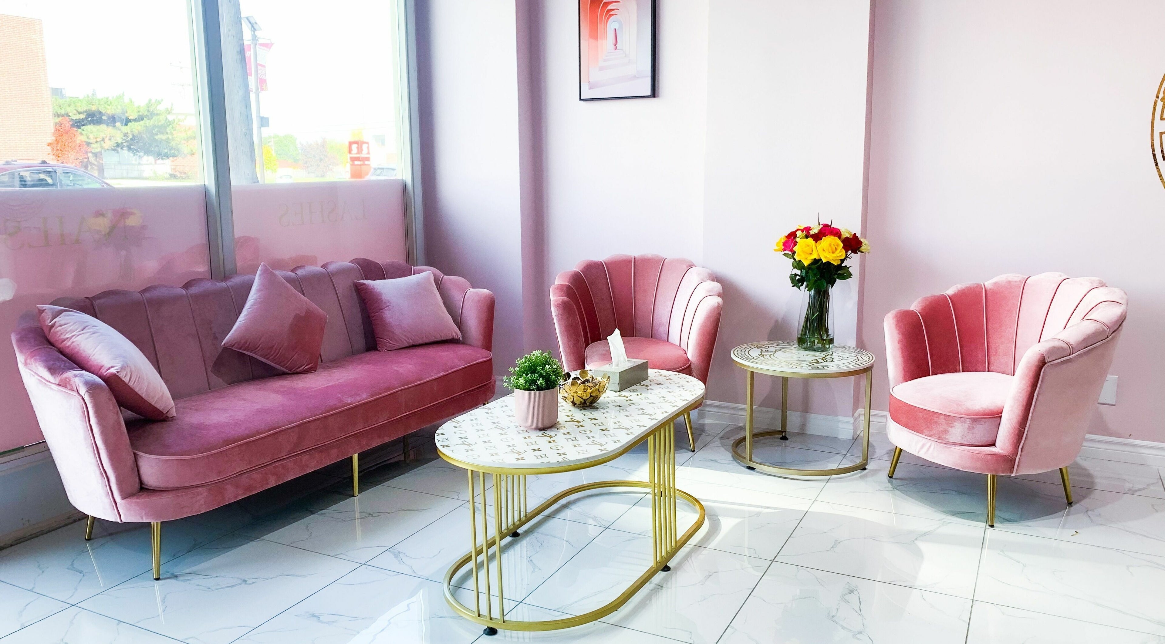 Cozy pink seating area in Goddess Salon, Toronto, Ontario, CA, with elegant chairs and table.