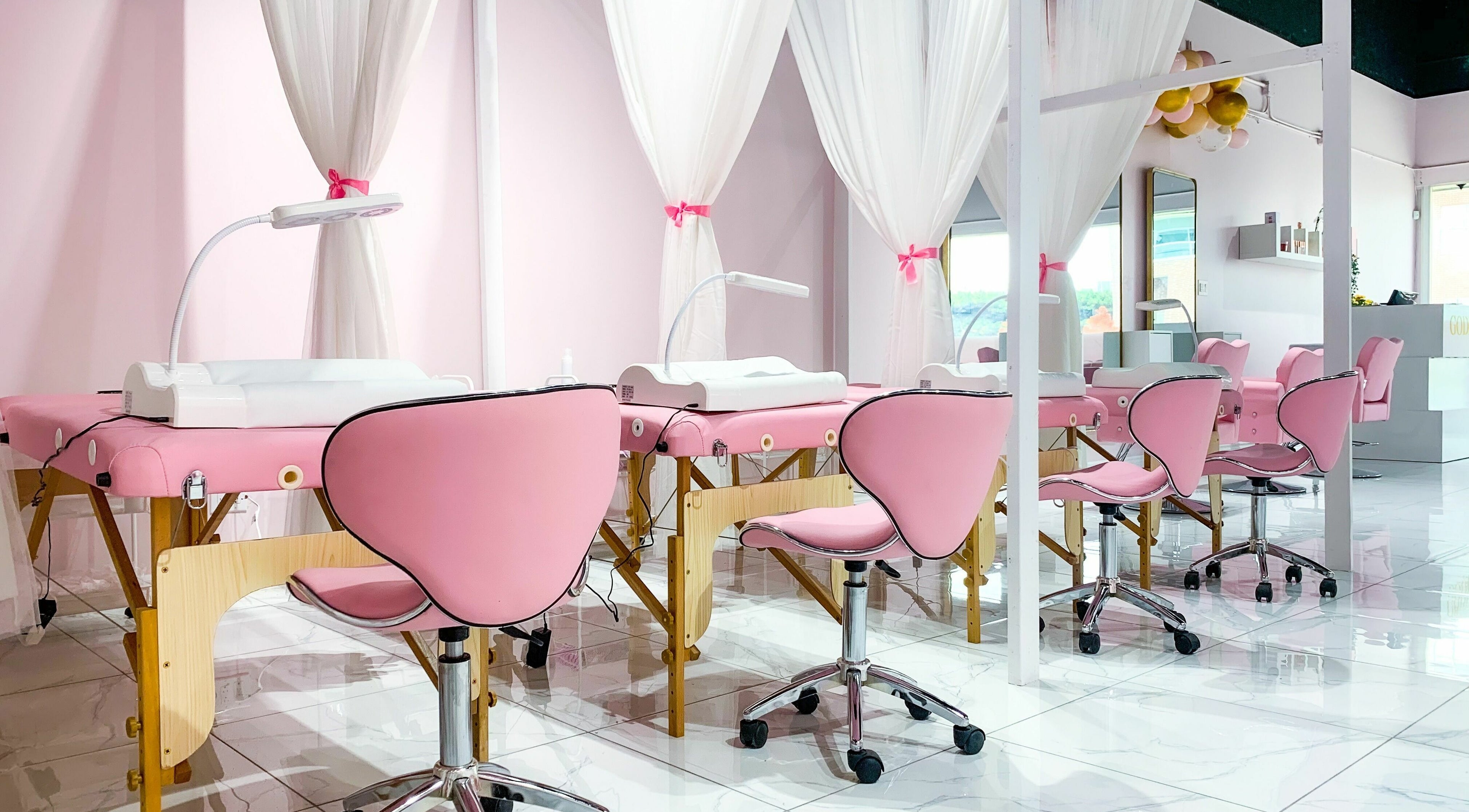 Goddess Salon's elegant pink spa setup in Toronto, Ontario, CA, featuring plush chairs and serene decor.