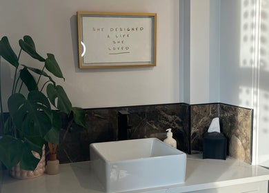 Chic washbasin at BEAUTY RACK, Skipton, England with lush plant and motivational art on the wall.
