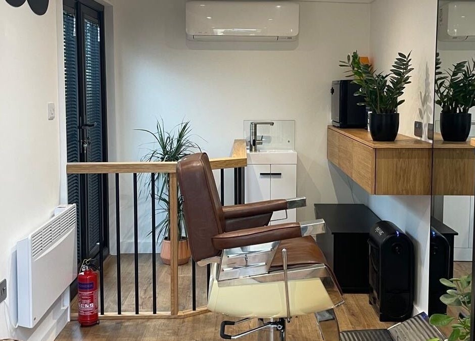 Sleek barber chair at Ridgeway Barbers, Newport, Wales, GB, with modern decor and potted plants.