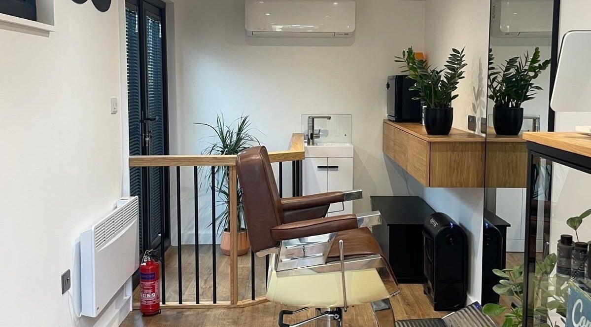 Sleek barber chair at Ridgeway Barbers, Newport, Wales, GB, with modern decor and potted plants.