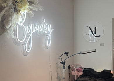 Chic ByMaisy beauty space in Bexleyheath, England, GB featuring illuminated signage and wellness equipment.