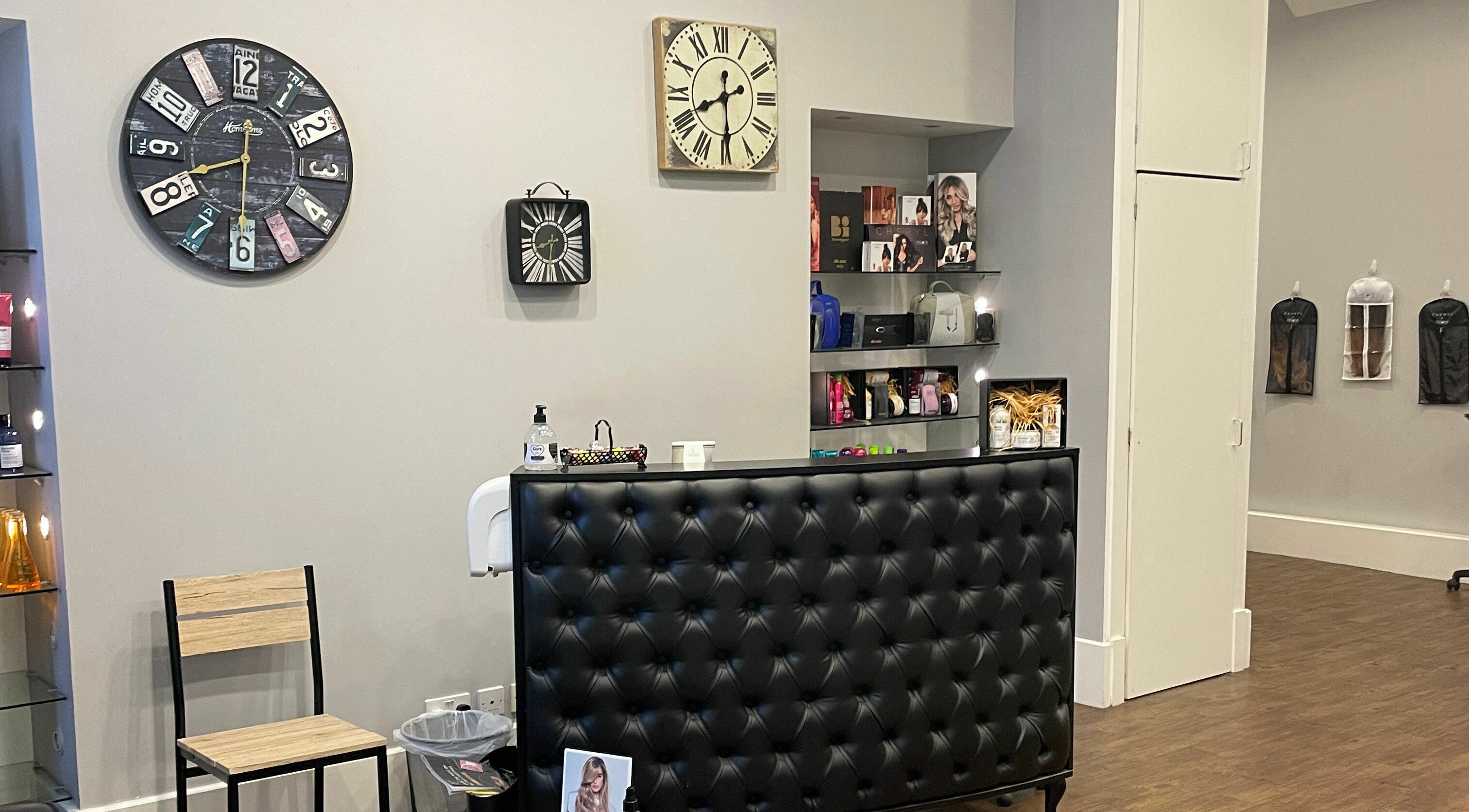 Stylish reception at House of Hair in Guernsey, Saint Peter Port, GG with clocks and shelves.