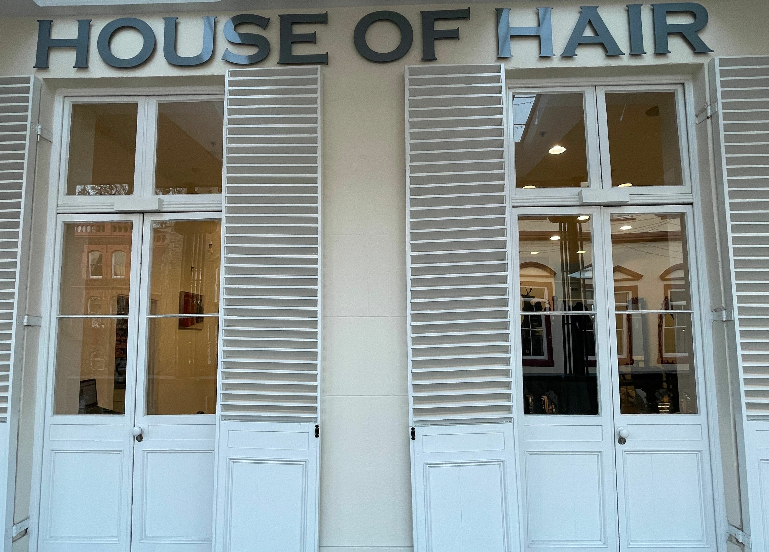 House of Hair facade featuring elegant white shutters in Guernsey, Saint Peter Port, GG.
