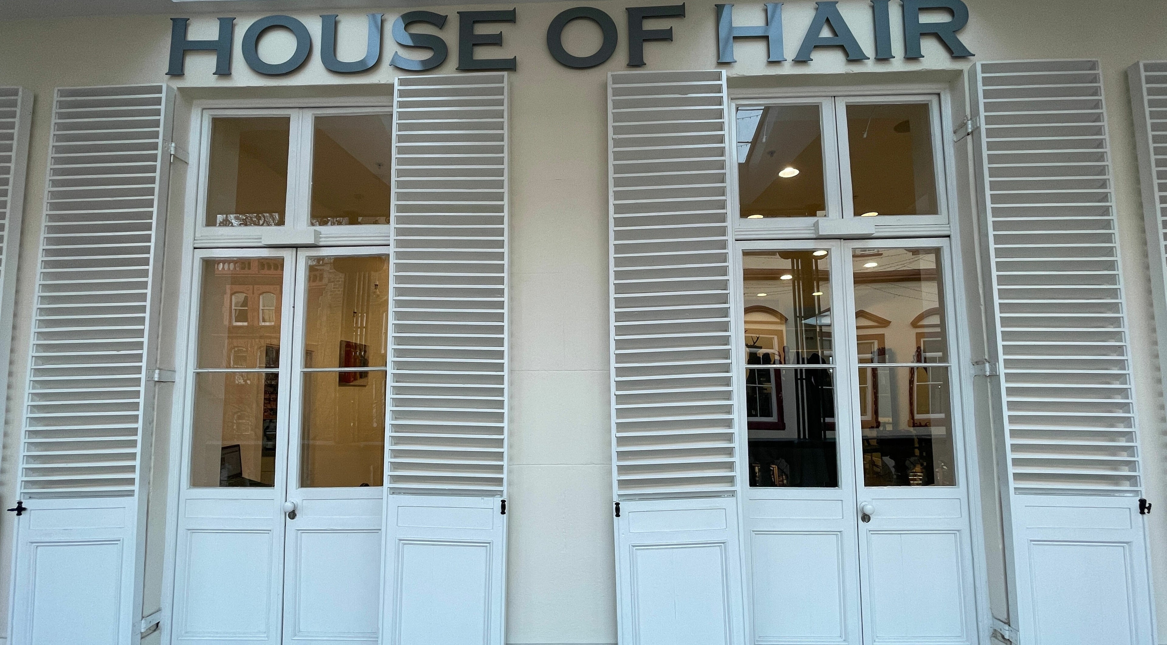 House of Hair facade featuring elegant white shutters in Guernsey, Saint Peter Port, GG.