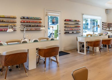 Interior of Powder Beauty Salon, Burbank, California, US, featuring stylish nail stations and colorful polish displays.