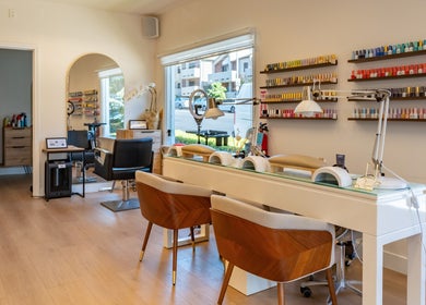 Chic interior of Powder Beauty Salon in Burbank, California, US, showcasing nail polish display and stylish chairs.