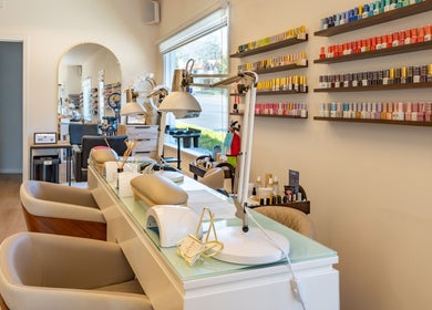 Powder Beauty Salon in Burbank, California offers a chic nail station with colorful polish display.