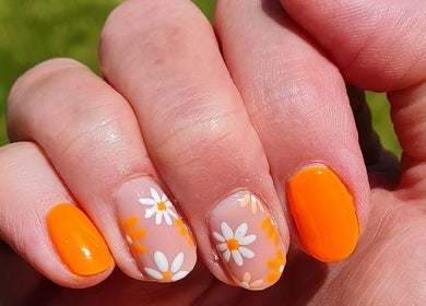Daisy nail art with orange accents at The Lash Lady, Basingstoke, England, GB. Perfect for summer vibes.