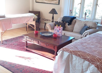 Welcoming massage room at Shass Therapy Mobile Massage in Gloucester, England, GB with cozy sofa and massage table.