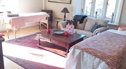Welcoming massage room at Shass Therapy Mobile Massage in Gloucester, England, GB with cozy sofa and massage table.