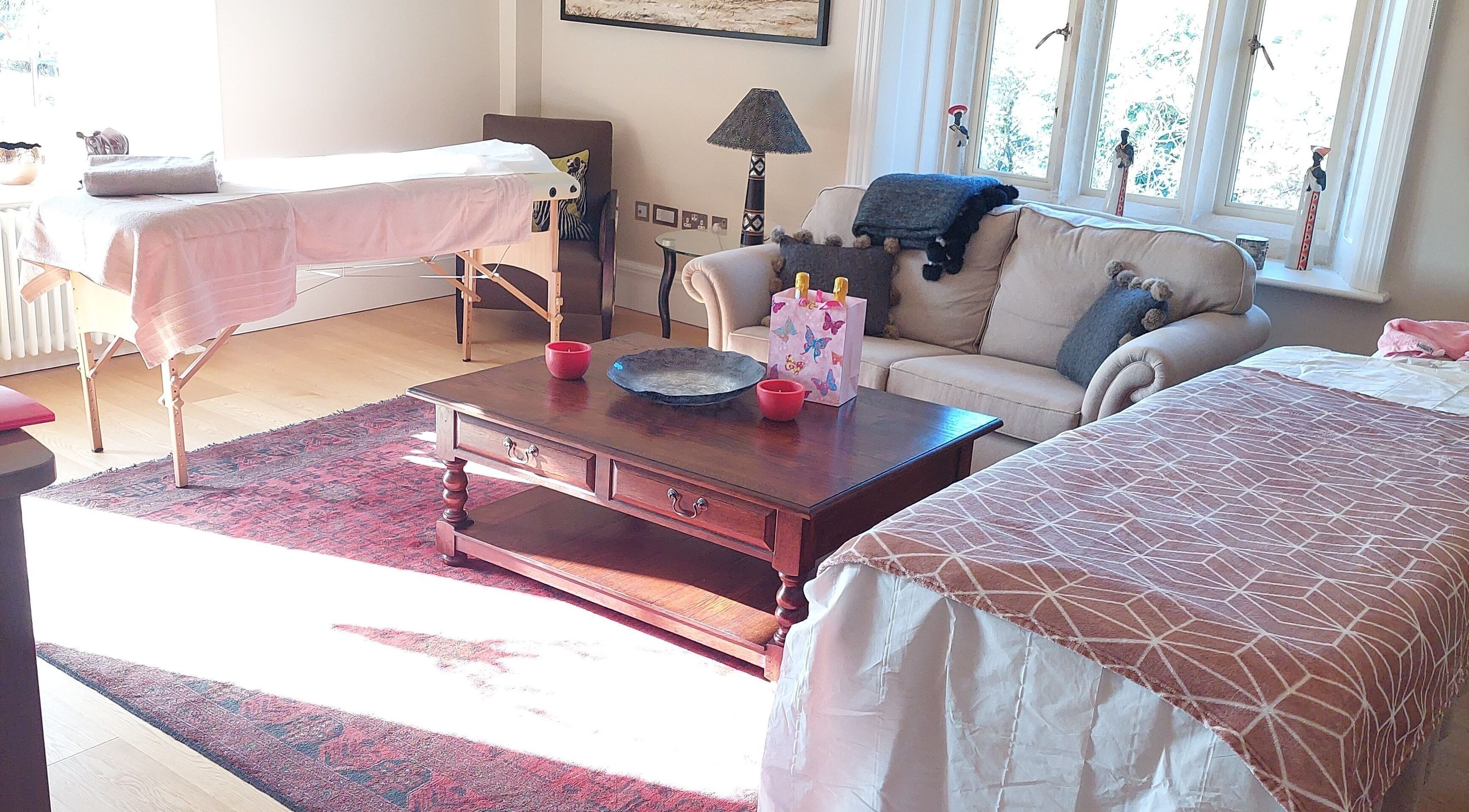 Welcoming massage room at Shass Therapy Mobile Massage in Gloucester, England, GB with cozy sofa and massage table.