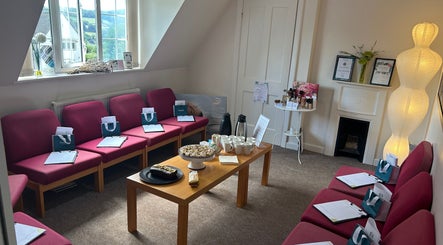 Relaxing lounge at Revive Beauty Painswick, Gloucester, England, GB, with chic seating and refreshments.