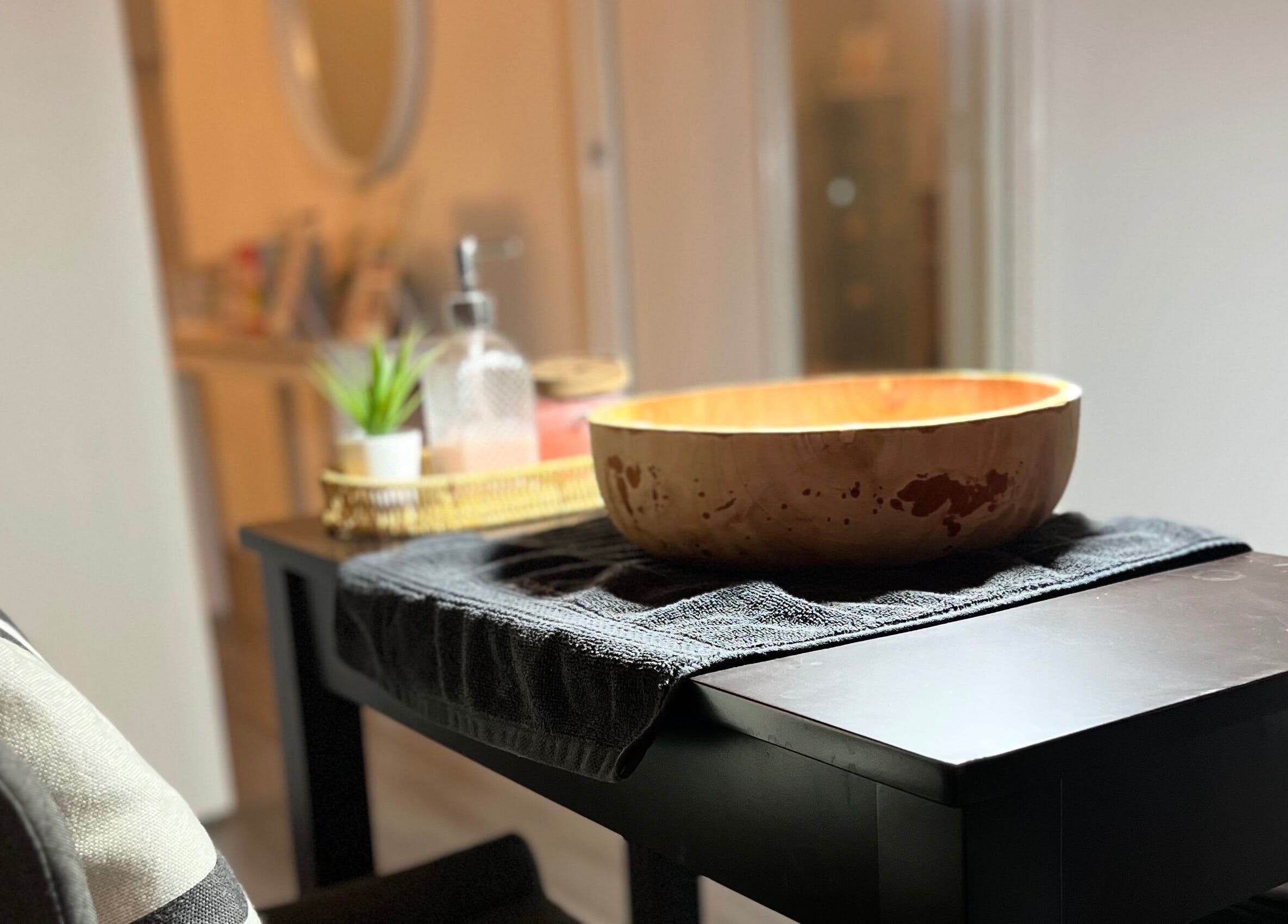 Elegant wooden bowl on a towel at NoonaLash Laman Areca, Nilai in Negeri Sembilan, MY spa room.