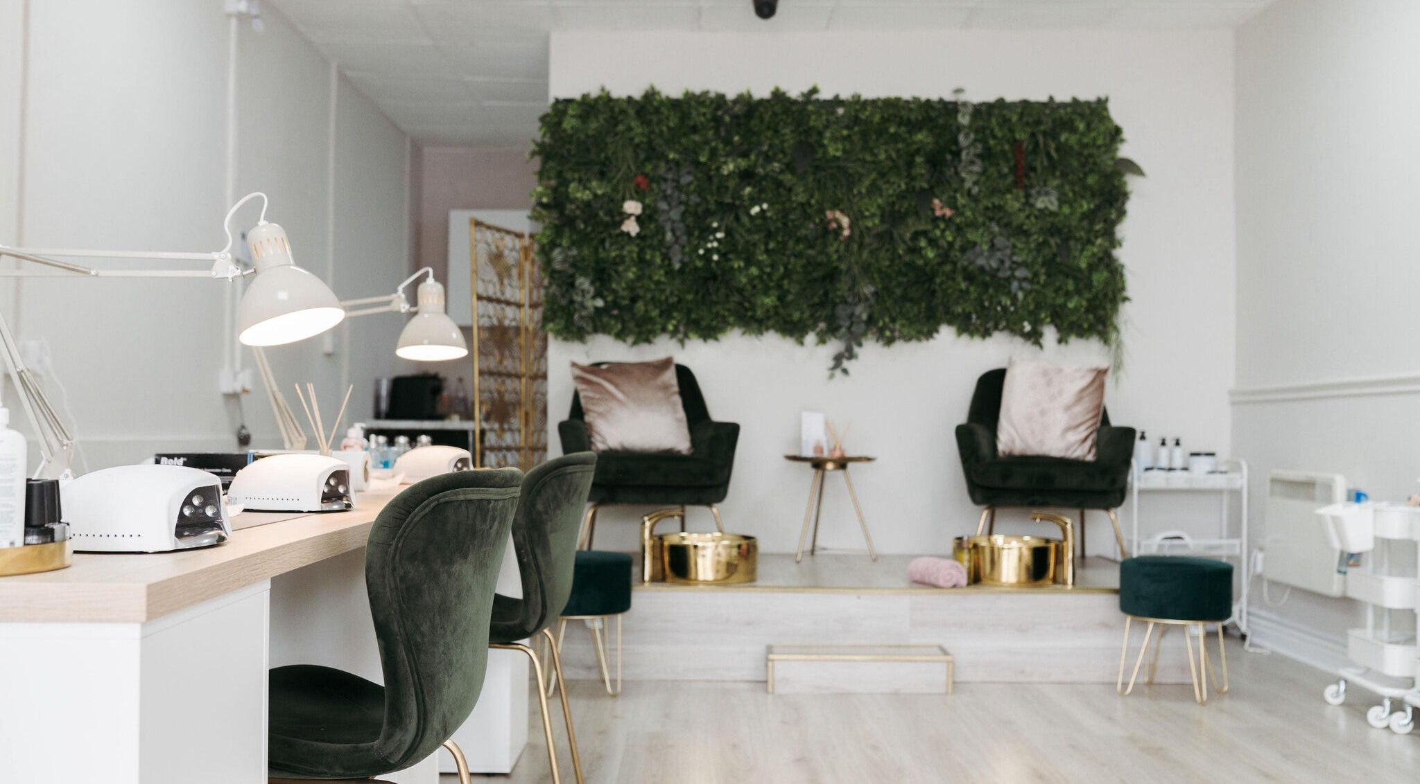 Cozy interior of Narelle Beauty in Castleford, England, GB, featuring plush chairs and a lush green wall.