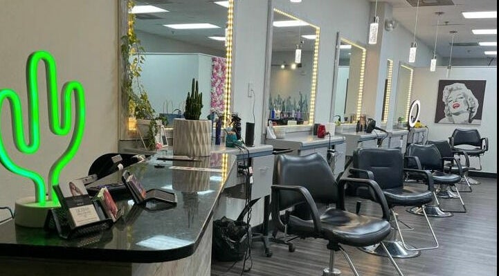 Interior of Cactus Salon in Addison, Texas featuring styling chairs and a neon cactus sign.